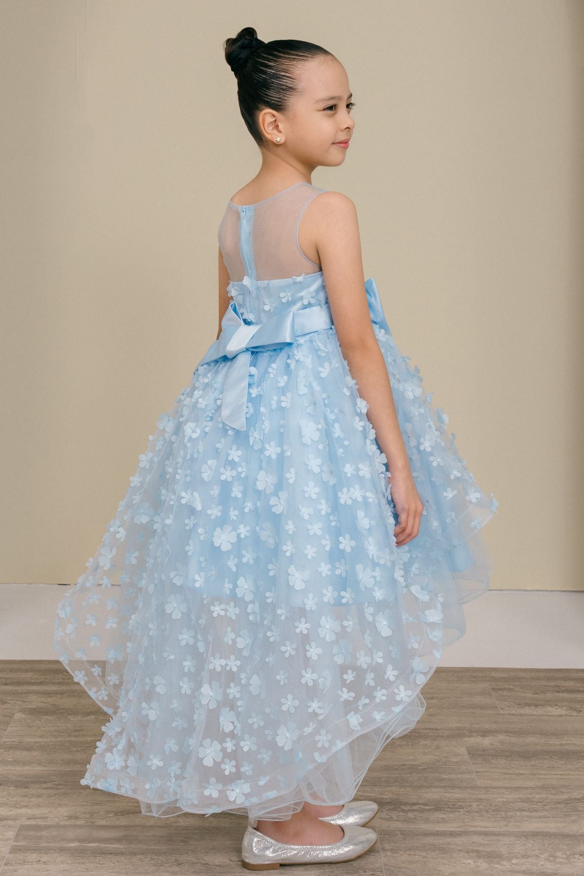 Blue flower girl dress side view highlighting hi-low silhouette and elegant structure.