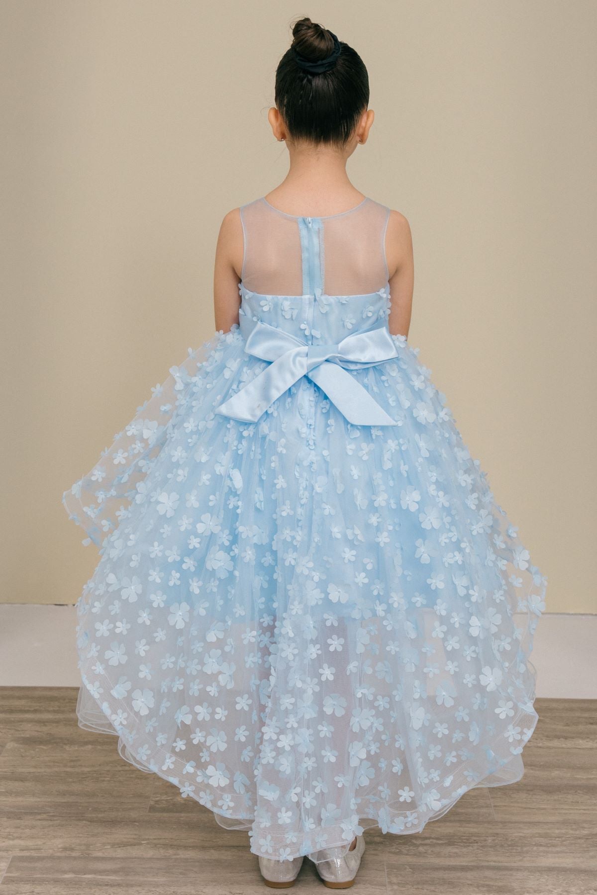 Back view of blue flower girl dress at formal event.