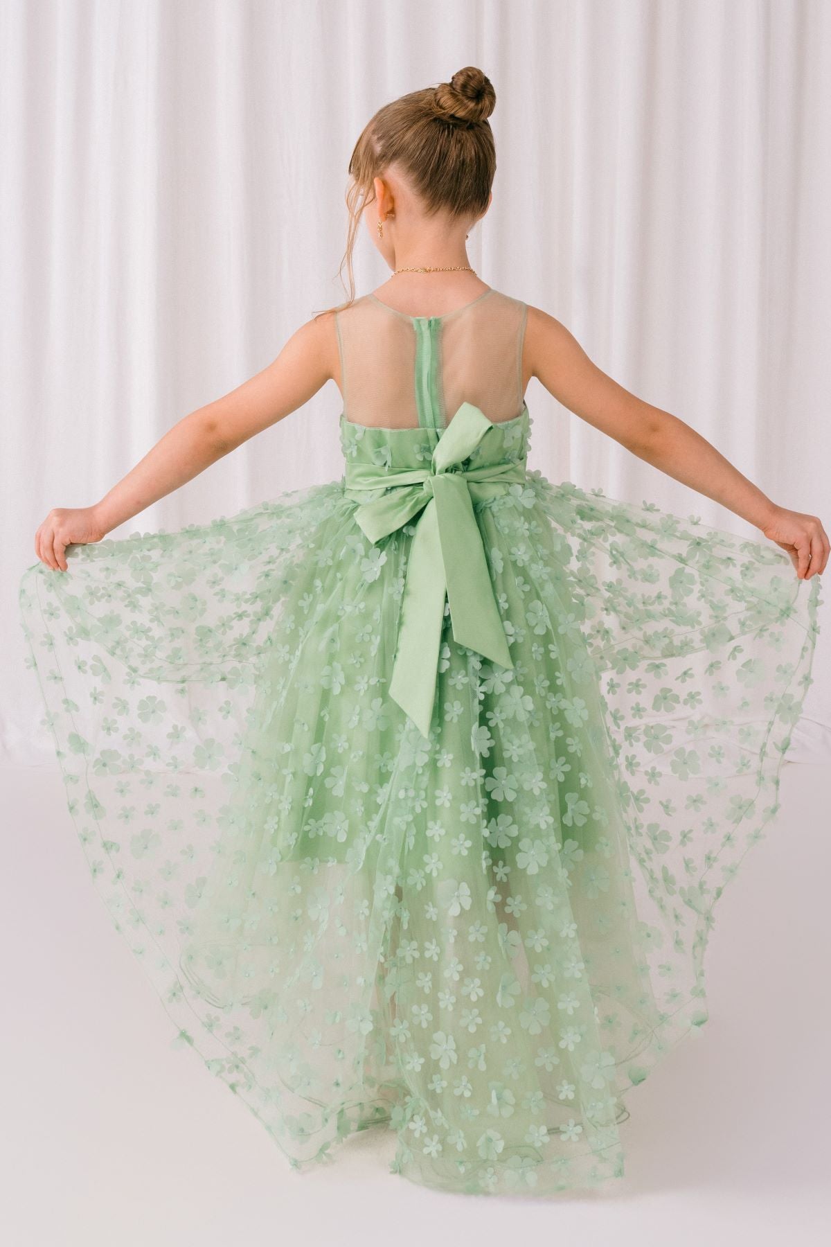Back view of sage flower girl dress at formal event.