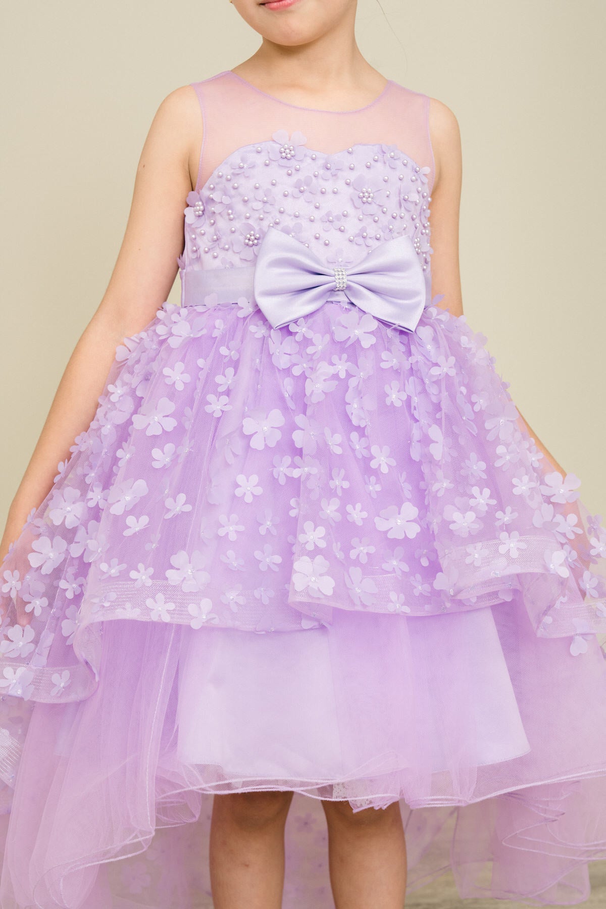 Close-up front view of lilac flower girl dress showing 3D floral detail and bodice texture.
