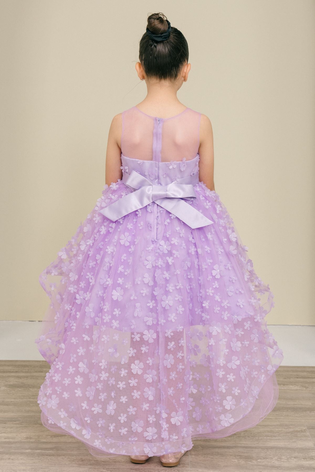 Back view of lilac flower girl dress at formal event.