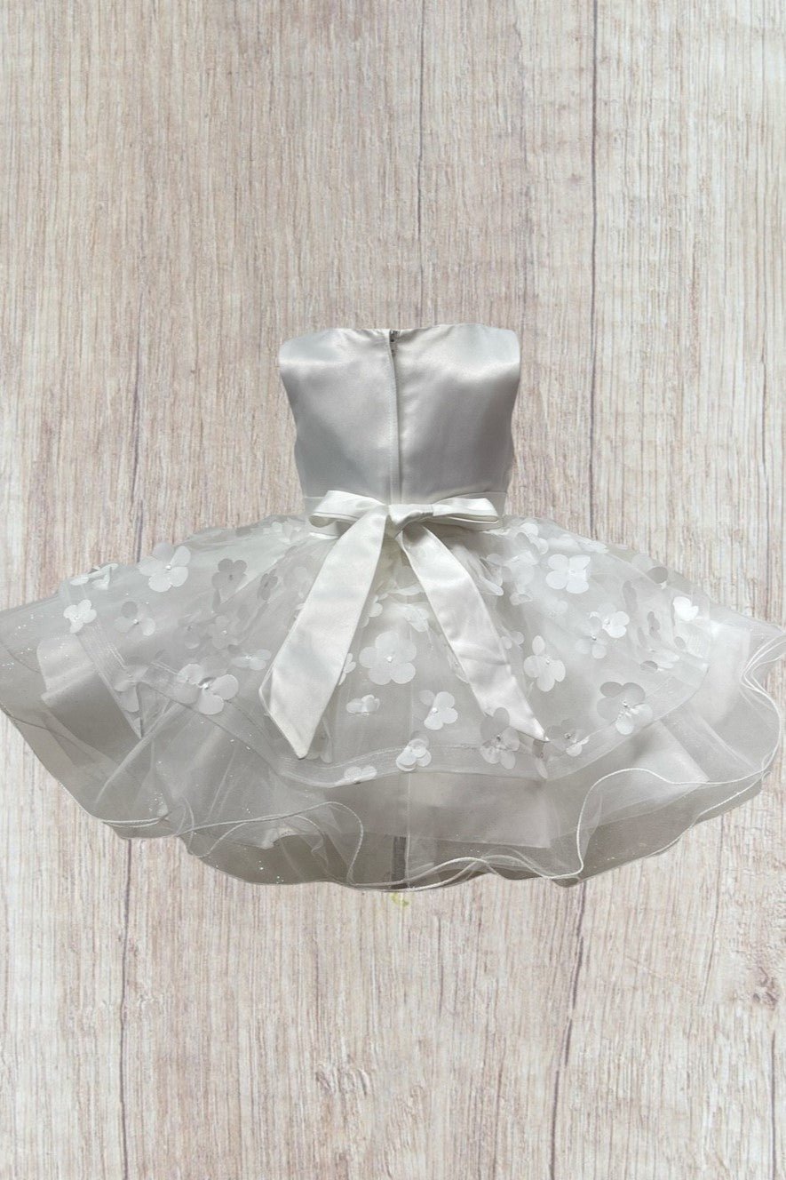 White flower girl dress back view highlighting elegant fit and classic silhouette.