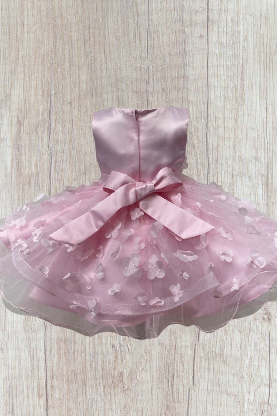 Pink flower girl dress back view highlighting elegant fit and classic silhouette.