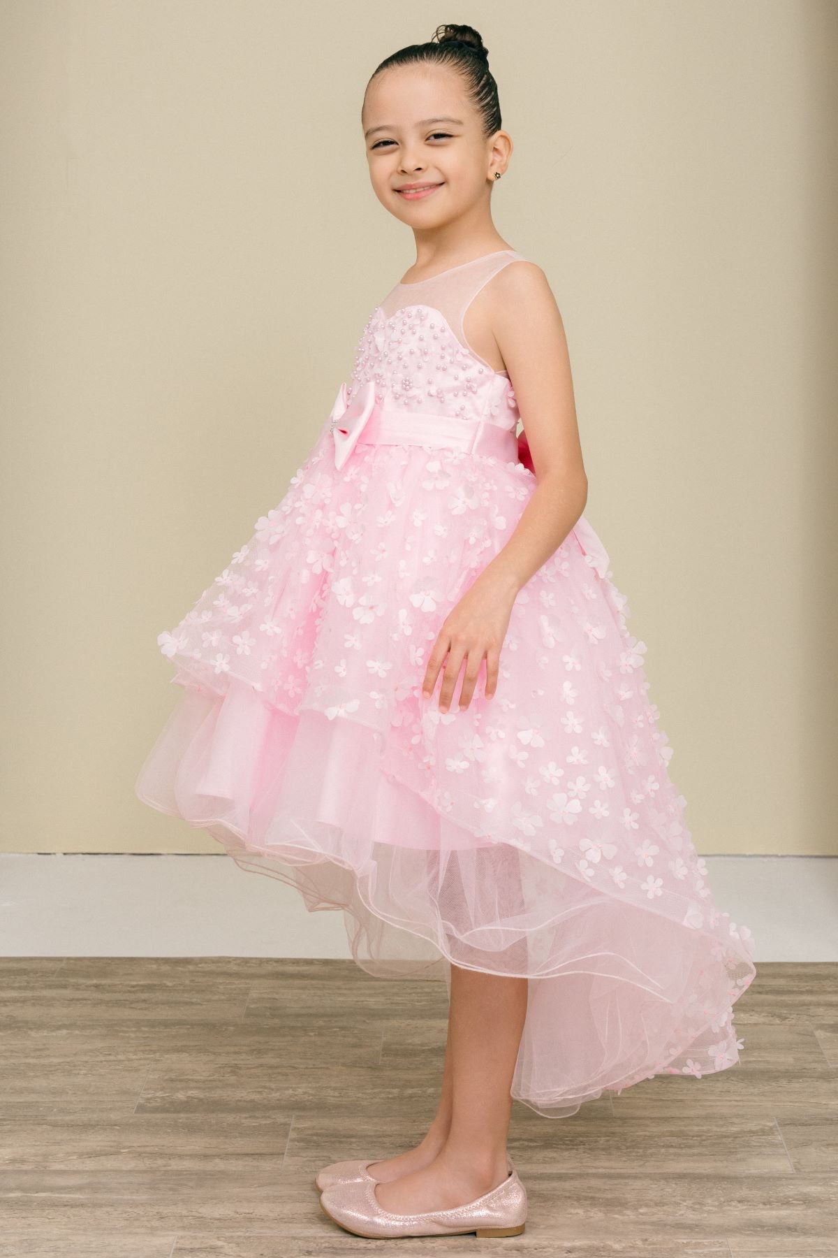 Pink flower girl dress side view highlighting hi-low silhouette and elegant structure.