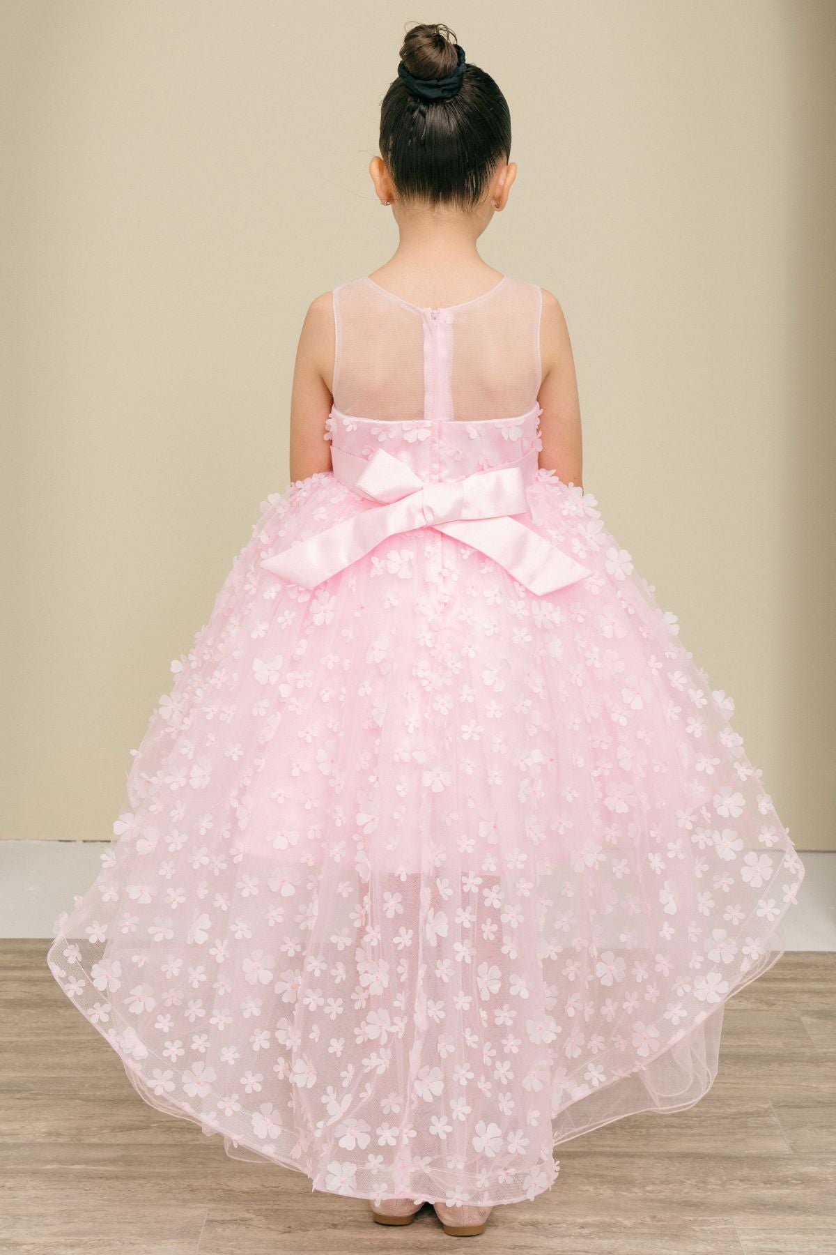 Back view of pink flower girl dress at formal event.