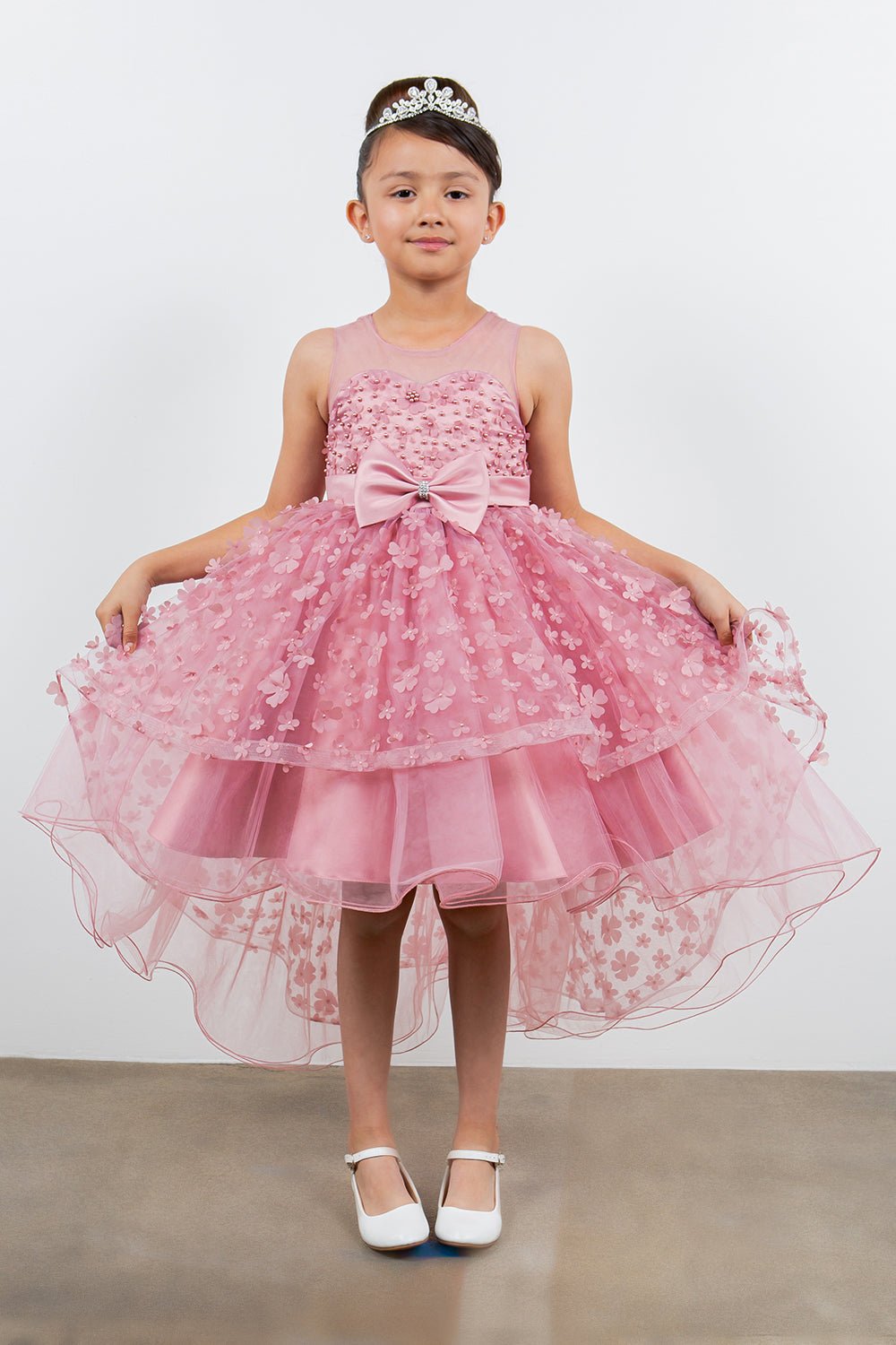 Dusty pink flower girl dress front view with illusion bodice and hi-low 3D flower skirt.
