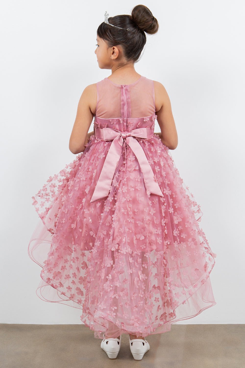 Back view of dusty pink flower girl dress at formal event.