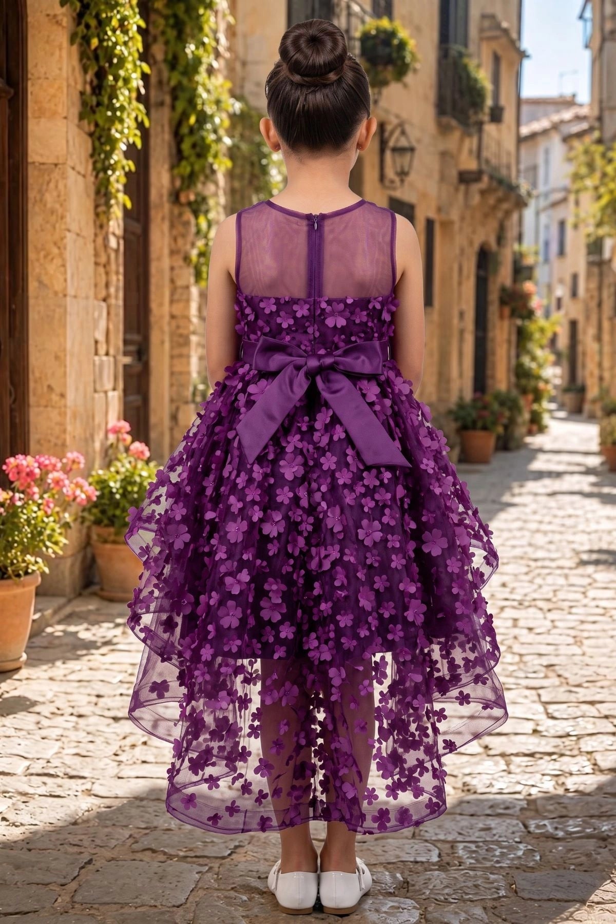 Displayed in a back view, the Purple flower girl dress has sheer back and oversized bow over the floral high-low train.