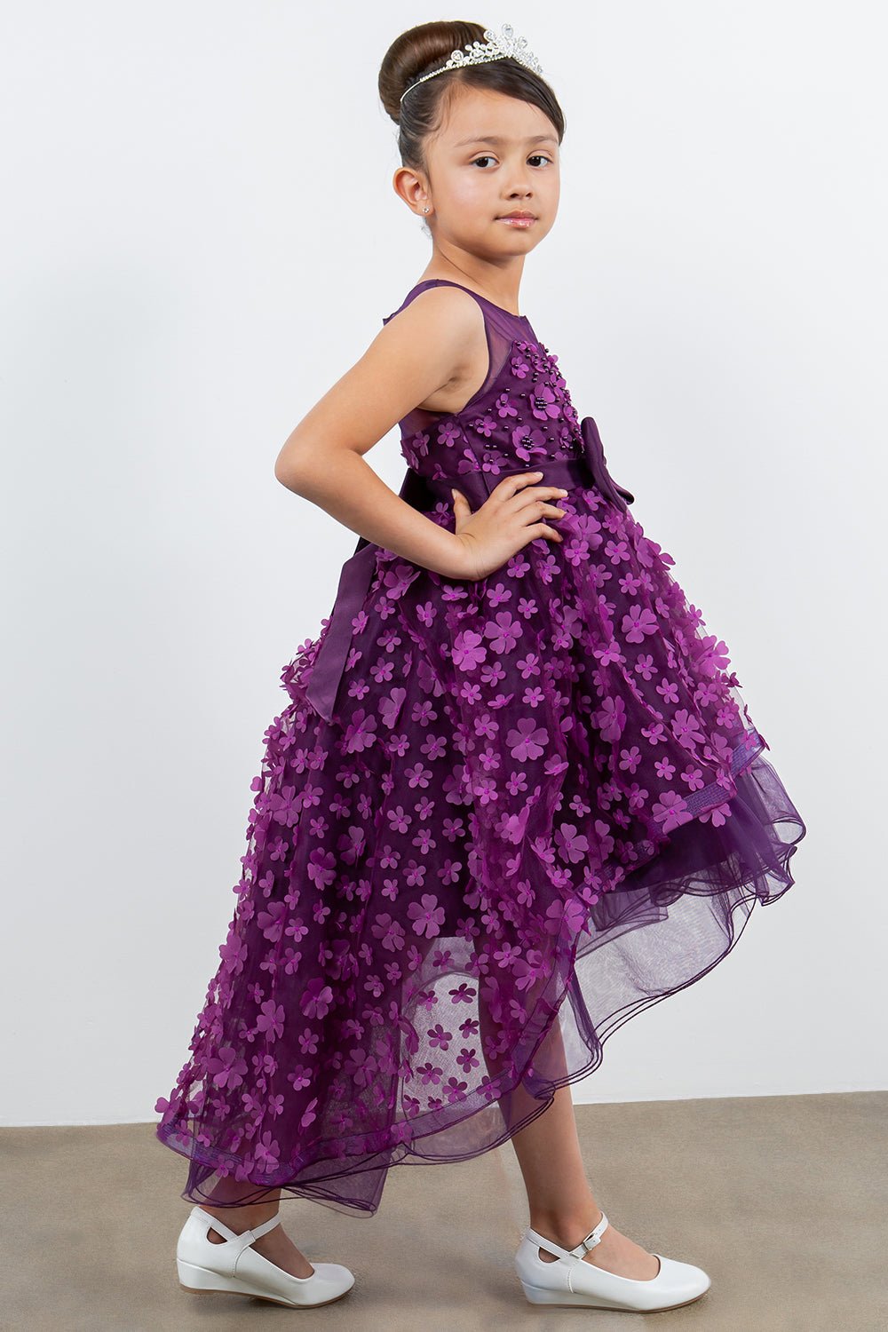 Close-up front view of purple flower girl dress showing 3D floral detail and bodice texture.