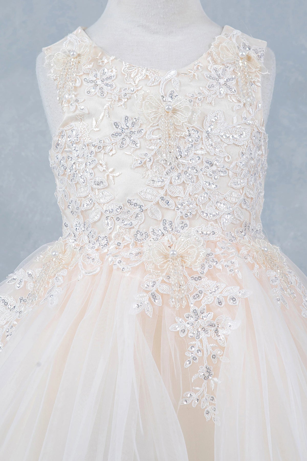 Detailed by floral lace across the bodice, the Champagne kids party dress reveals its construction.