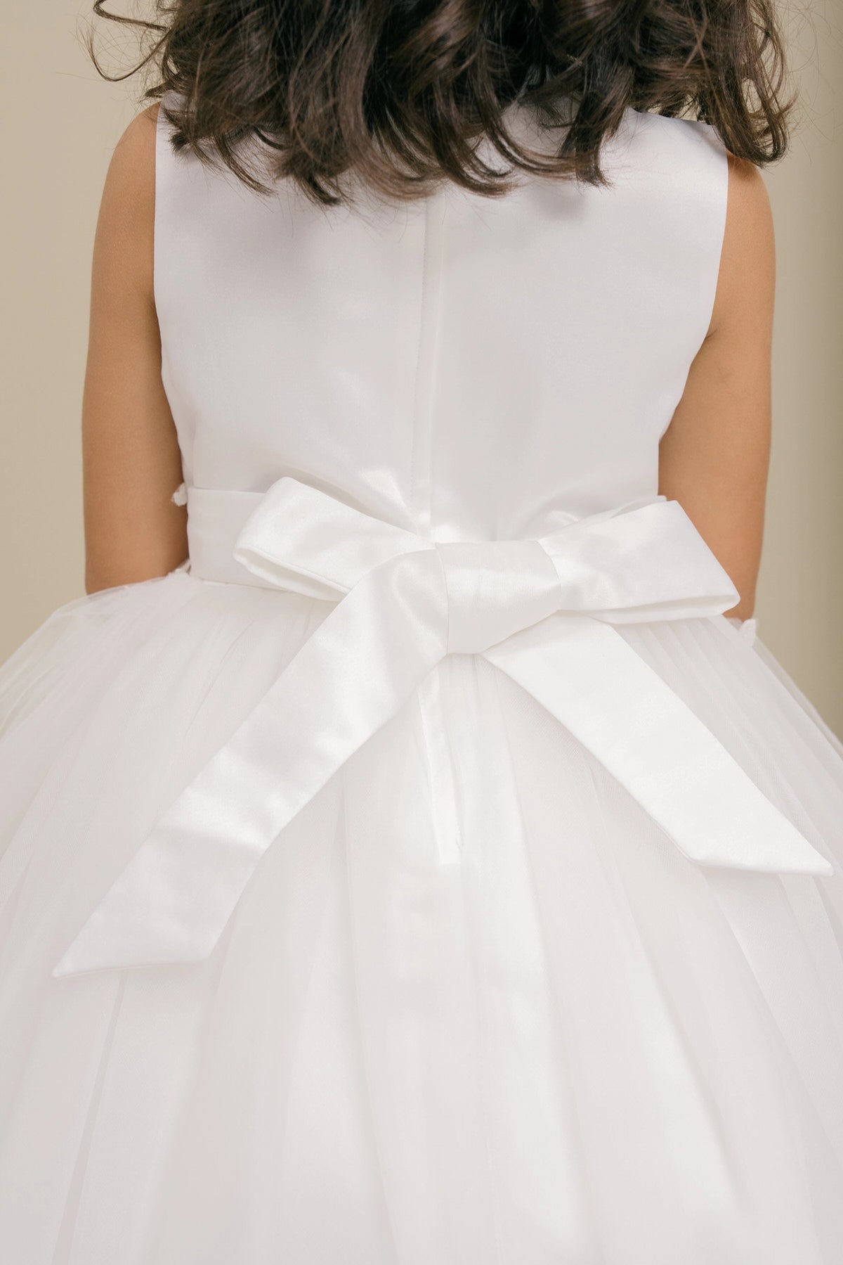 Detailed by a satin waist bow, the Off-White kids party dress reveals its construction.