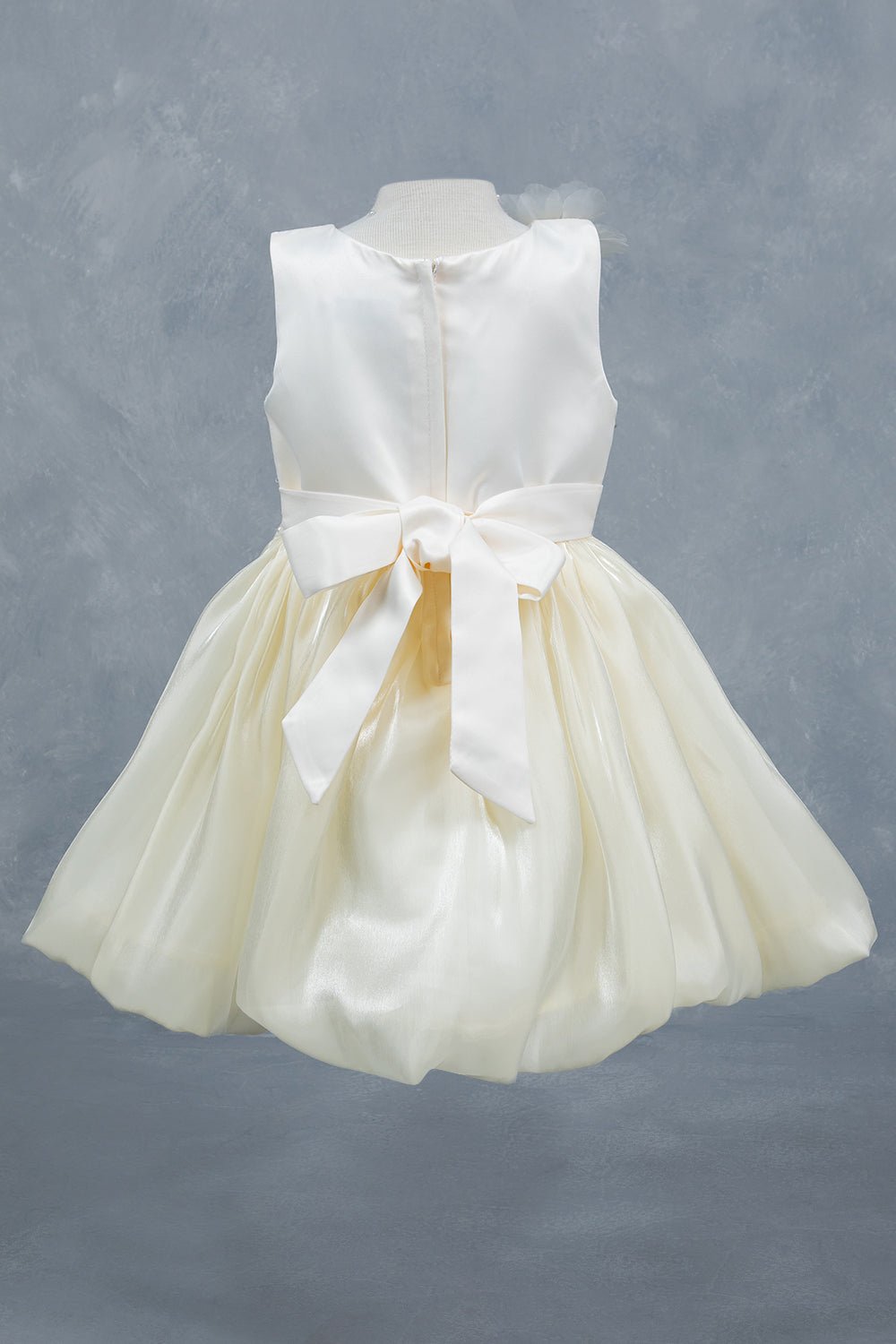 Ivory flower girl dress back view highlighting elegant silhouette and soft layered design.