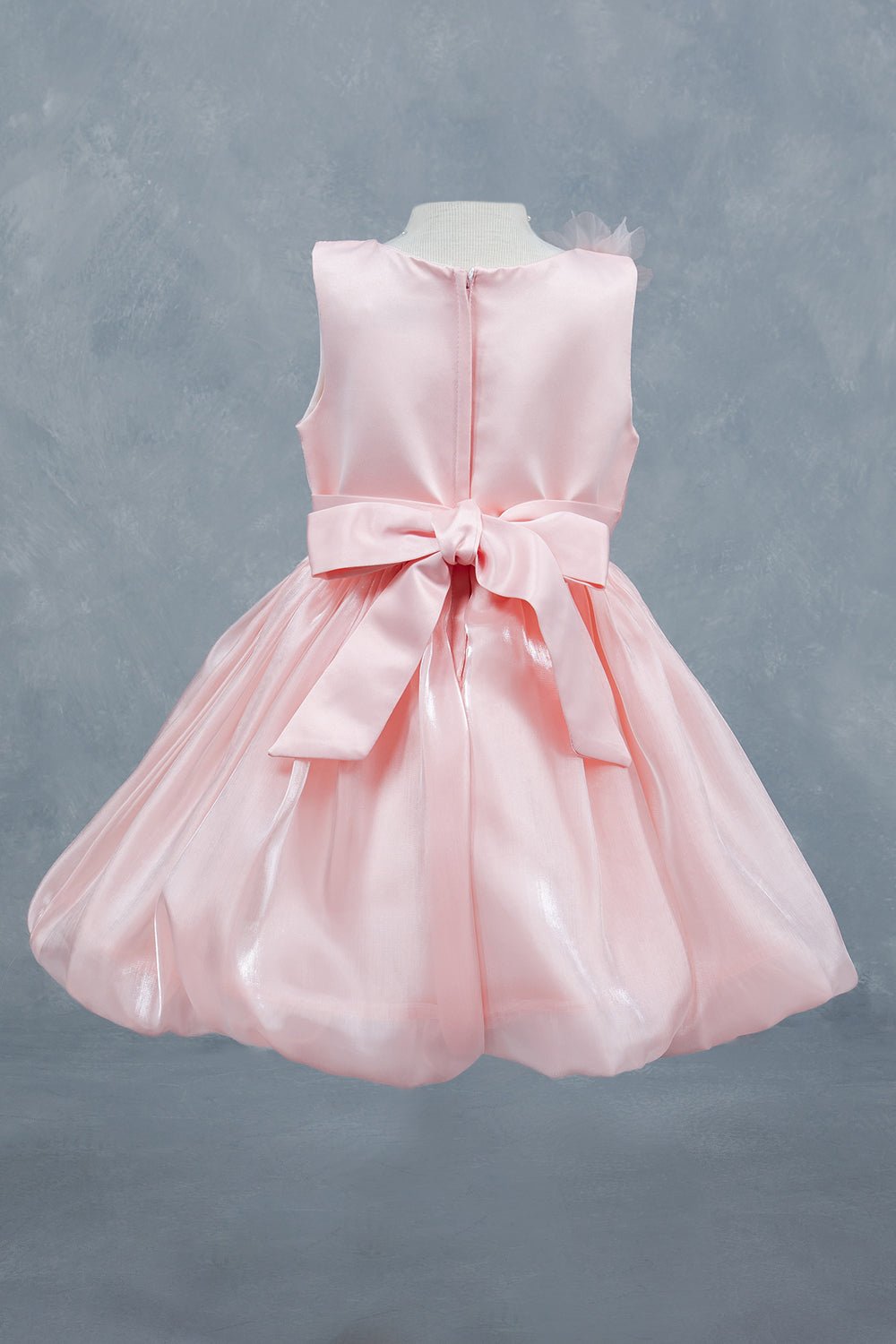 Peach flower girl dress back view highlighting elegant silhouette and soft layered design.