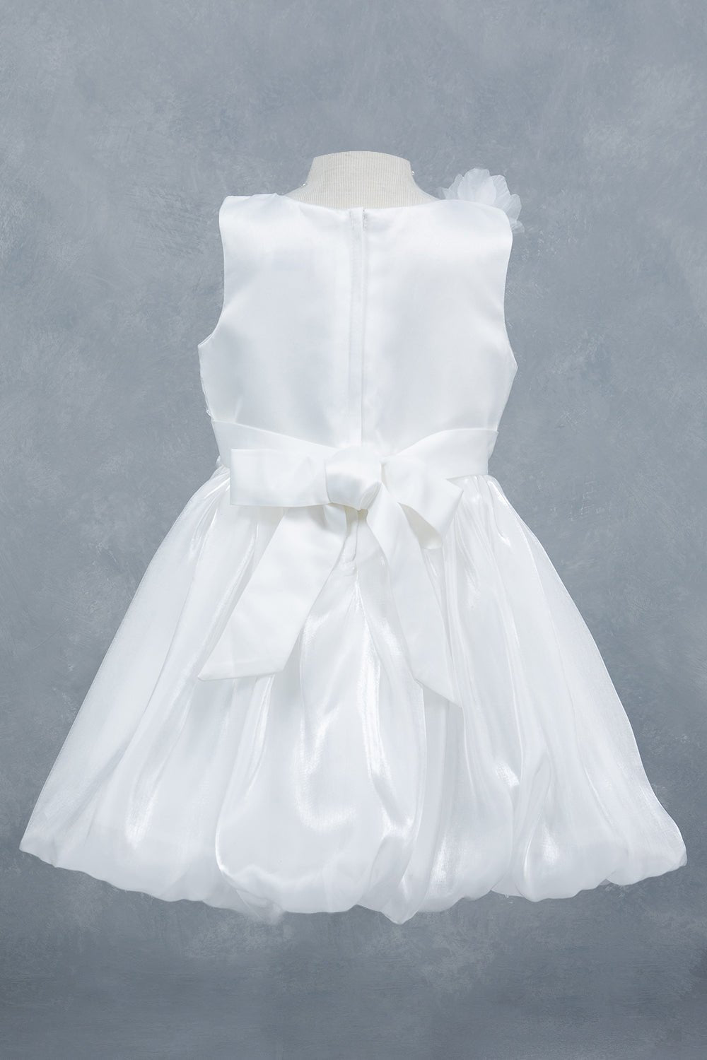 White flower girl dress back view highlighting elegant silhouette and soft layered design.