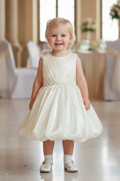 Kid Wearing Ivory Flower Girl Dress Front View With Pleated Bodice And Floral Shoulder Detail