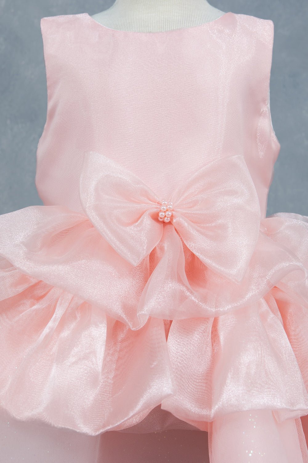 Peach flower girl Dress Front View With Floral Waist Detail And Layered Tulle Skirt.