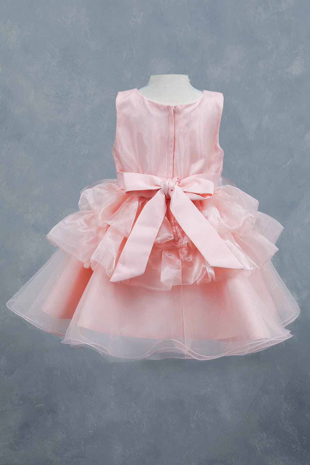Peach flower girl dress back view highlighting layered tulle and soft silhouette.