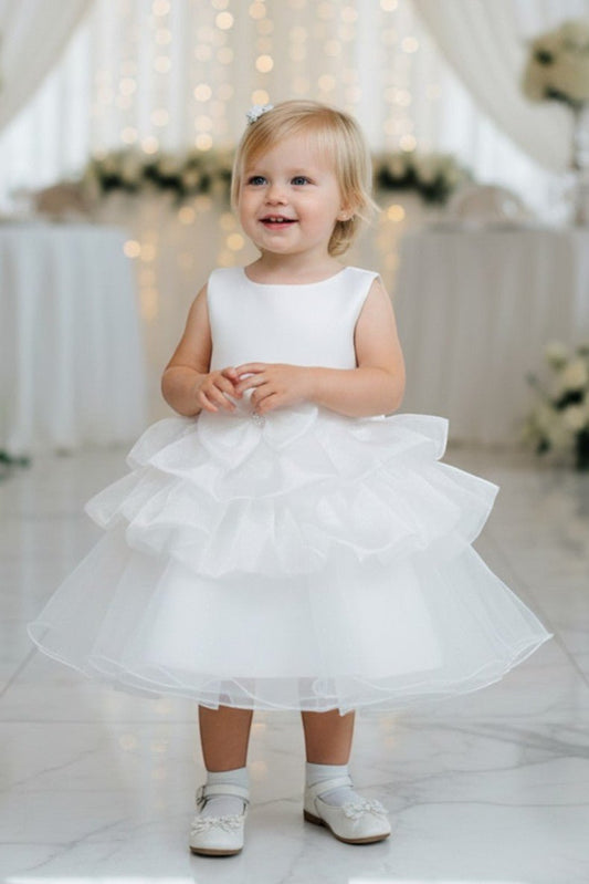 Kid Wearing White Flower Girl Dress Front View With Floral Waist Detail And Layered Tulle Skirt