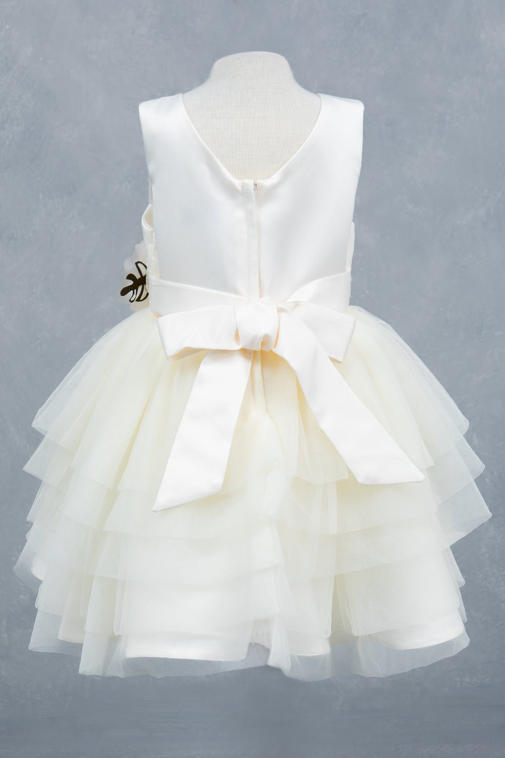 Ivory flower girl dress back view highlighting layered tulle and soft silhouette.