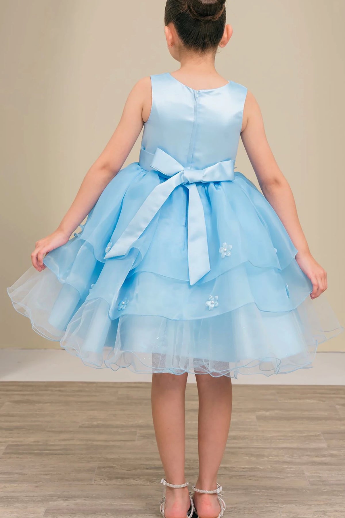 A light blue flower girl dress with a bow.