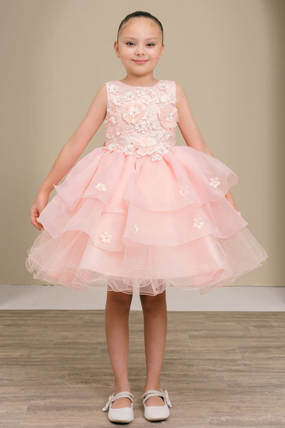 Young girl wearing a peach blush floral dress on a plain background