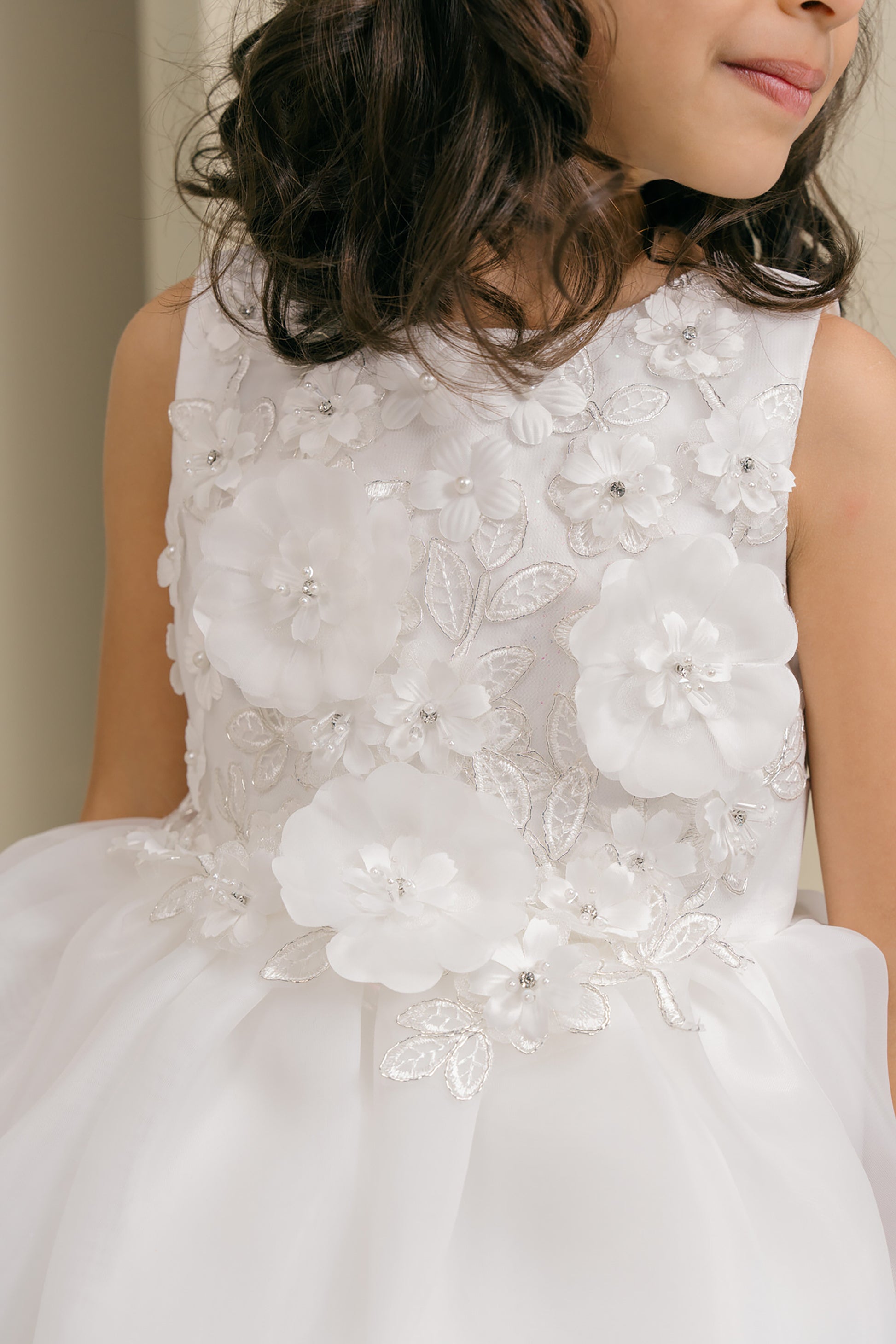 White floral dress with intricate details on a plain background