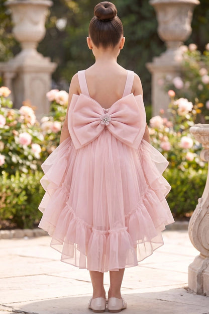 A Blush flower girl dress showing oversized back bow above the ruffled hem.