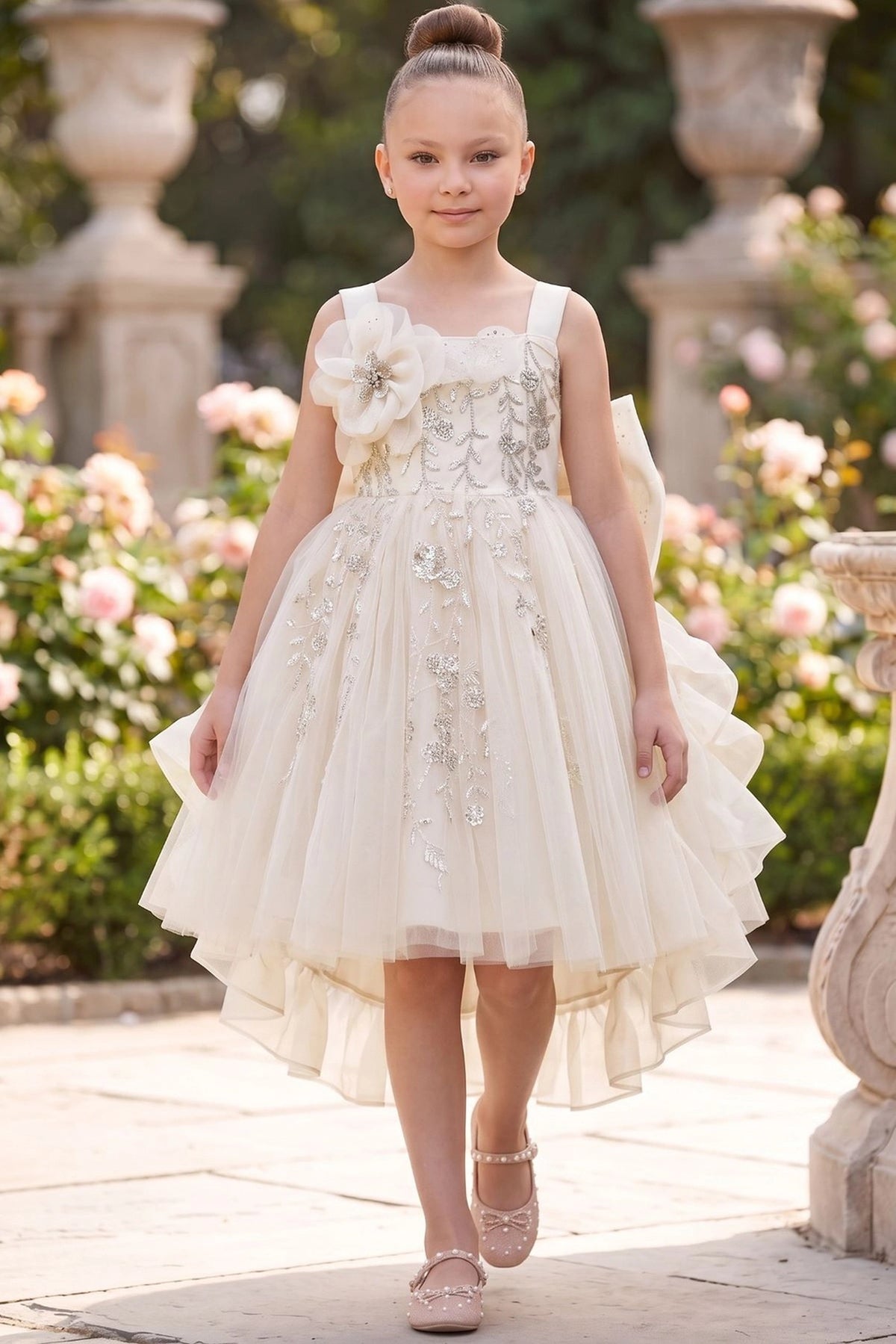 Ivory flower girl dress features floral embroidery and layered ruffled skirt.