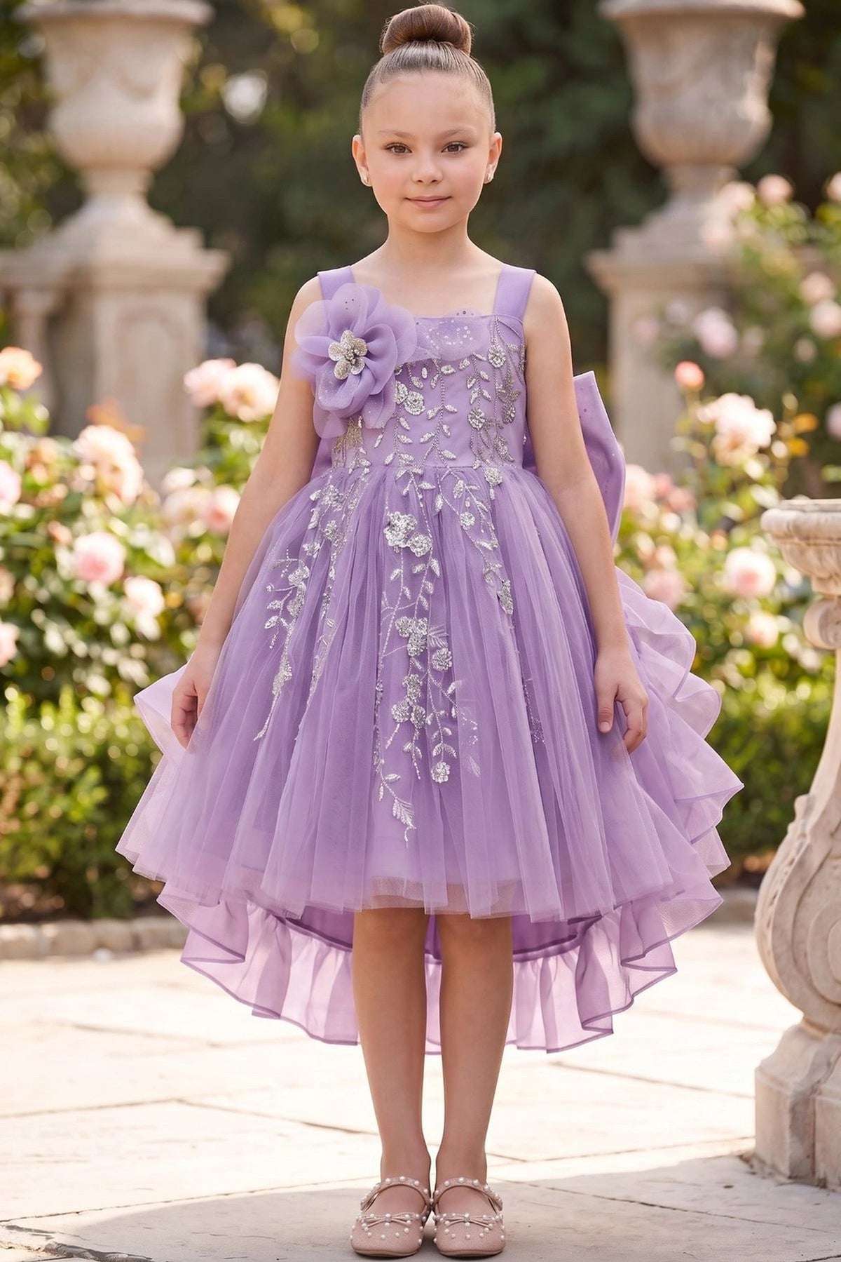 Lilac flower girl dress features floral embroidery above the ruffled skirt.