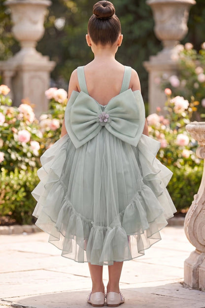 A Sage flower girl dress showing open back with bow and ruffled tulle hem.