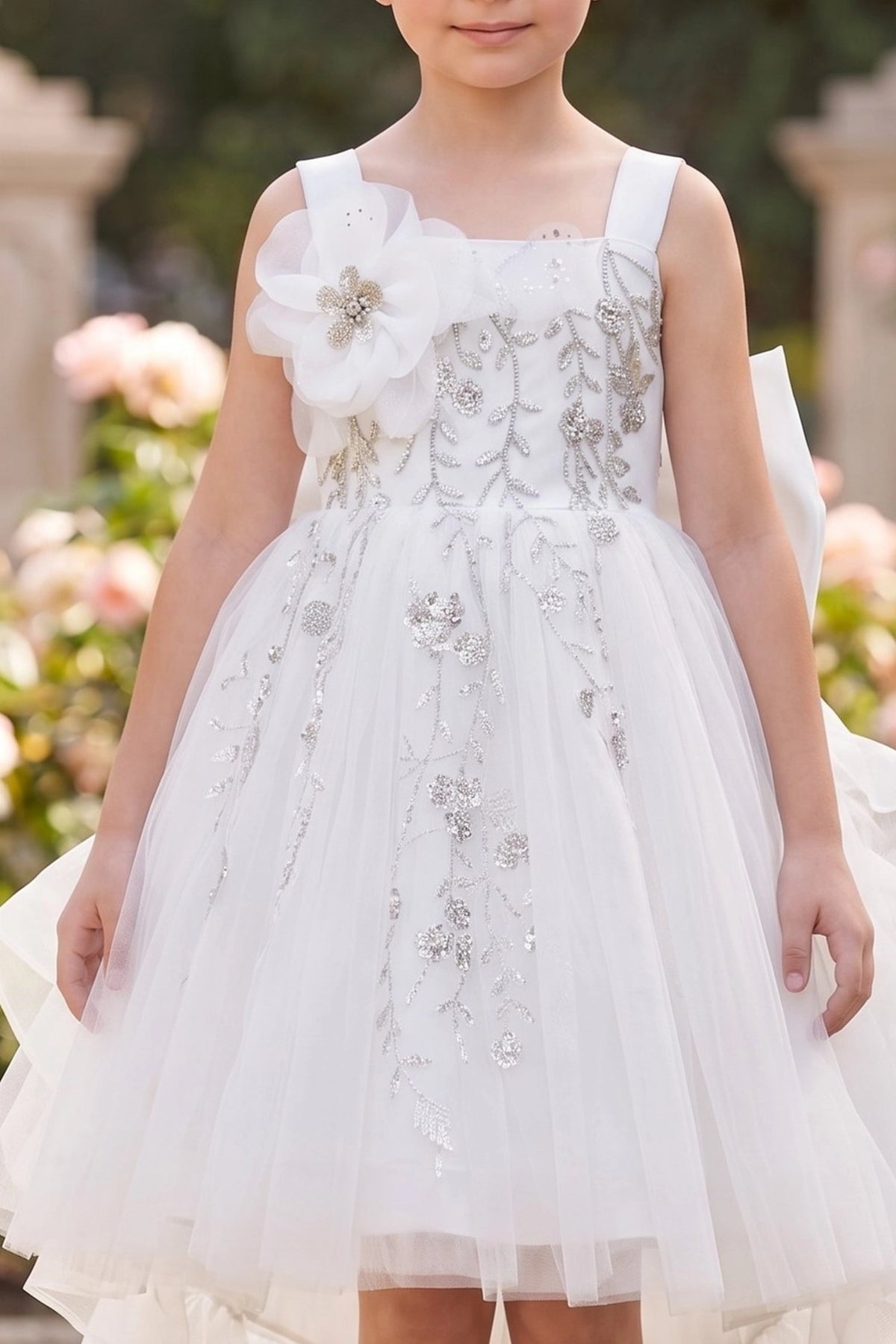 Visible on this White flower girl dress: dimensional shoulder flower above floral embroidery.