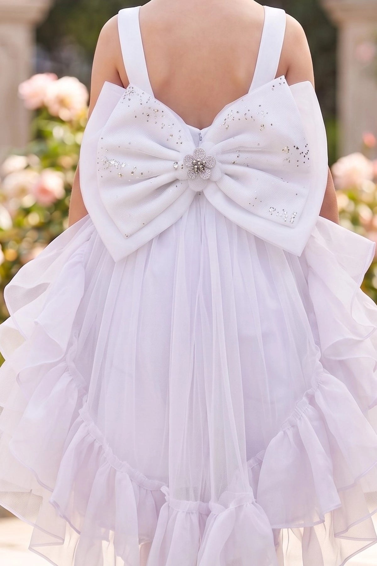 Featuring large jeweled bow below the shoulder straps on the White flower girl dress.