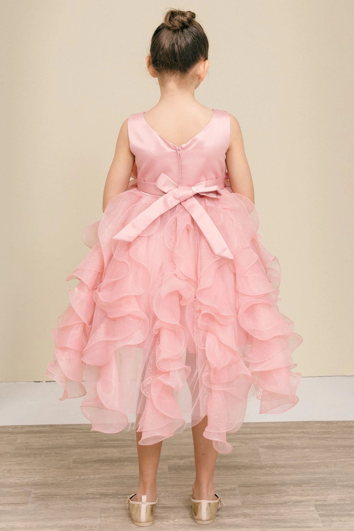 Finished details of a bow above petal-shaped ruffles distinguish the Rose kids party dress.