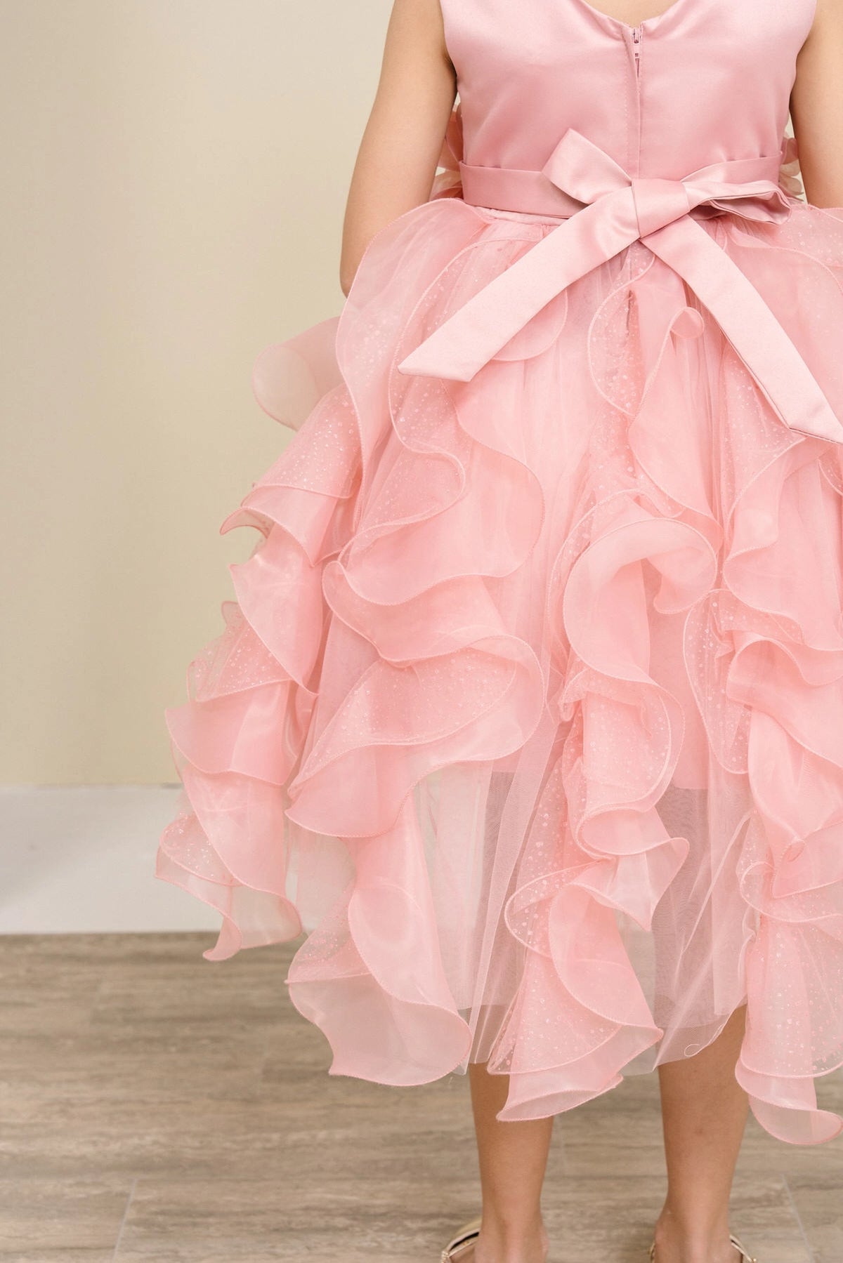 Detailed by a bow above petal-shaped ruffles, the Rose kids party dress reveals its construction.