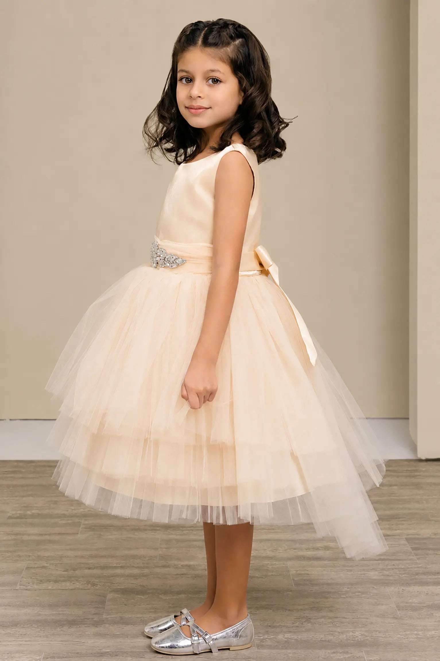 Champagne flower girl dress with satin bodice, rhinestone waistband, satin bow back, and layered tulle skirt