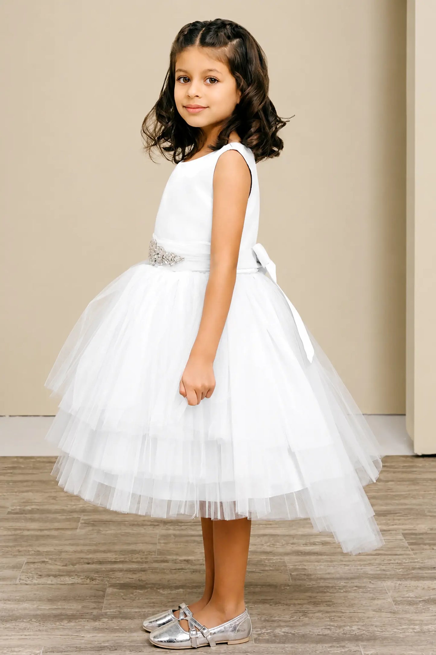 White flower girl dress with satin bodice, rhinestone waistband, satin bow back, and layered tulle skirt