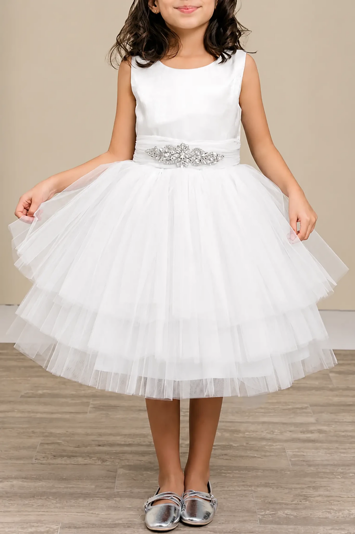 White flower girl dress with satin bodice, rhinestone waistband, and layered glitter tulle skirt.