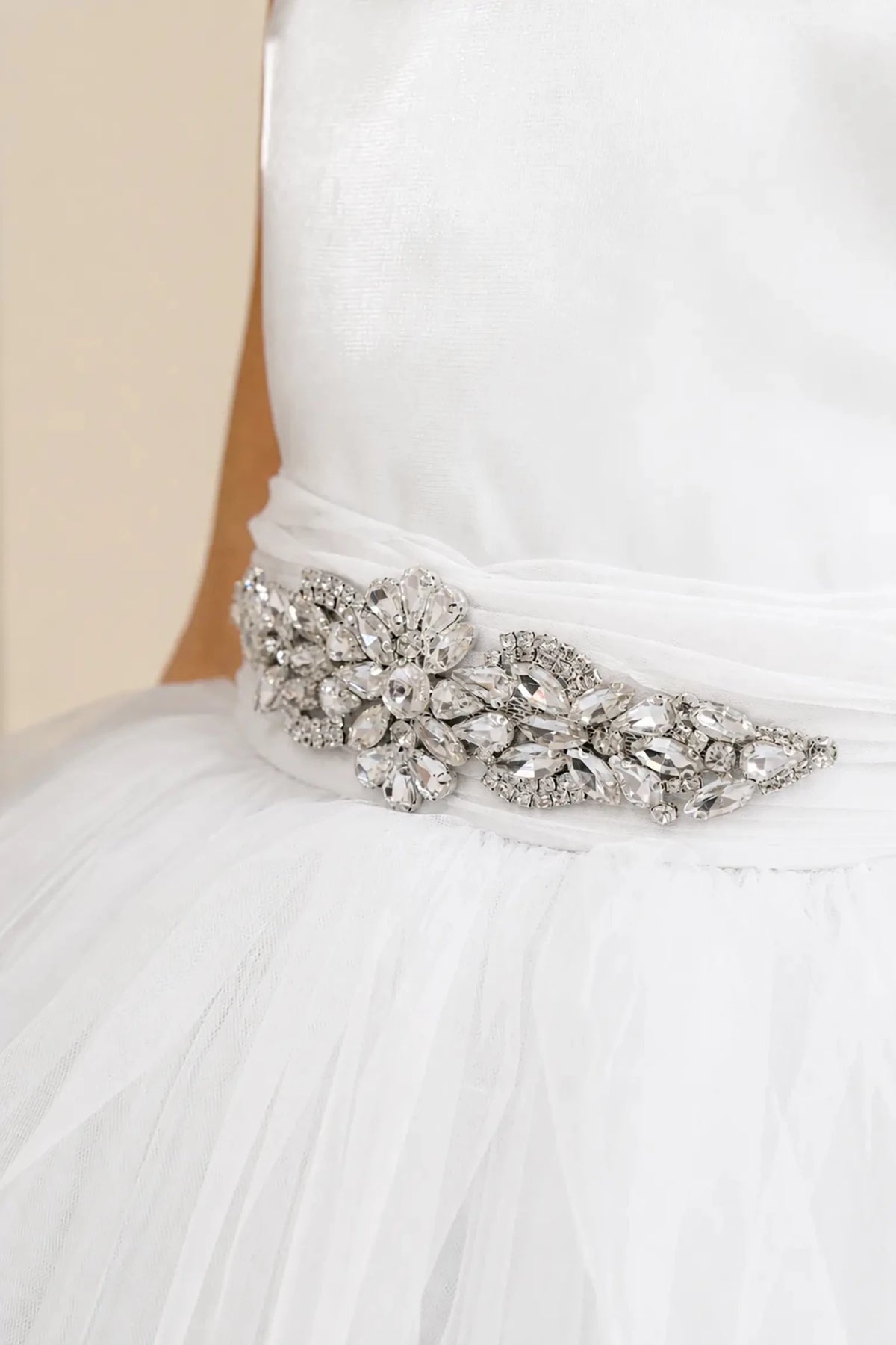 White flower girl dress with rhinestone waistband detail and satin bodice.