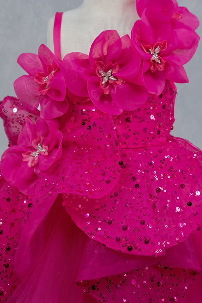 Close-up front view of fuchsia dress showing shimmering fabric and bow accent