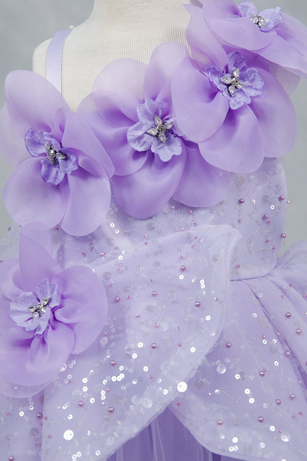 Close-up front view of lilac dress showing shimmering fabric and bow accent