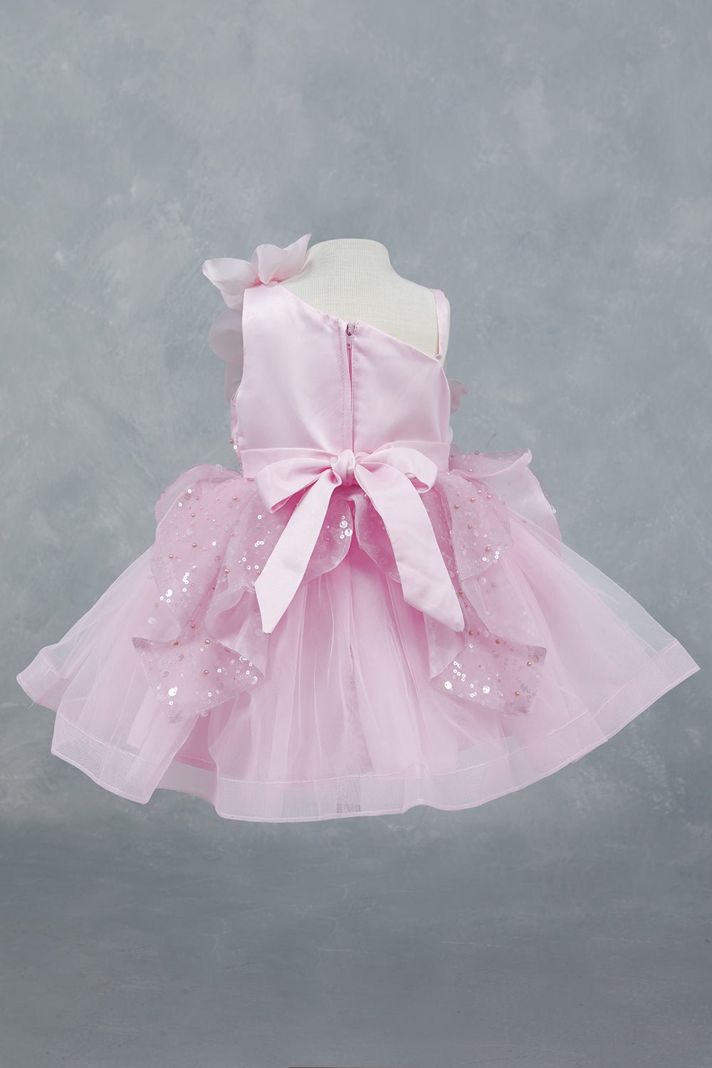 Pink dress back view highlighting layered ruffles and elegant silhouette