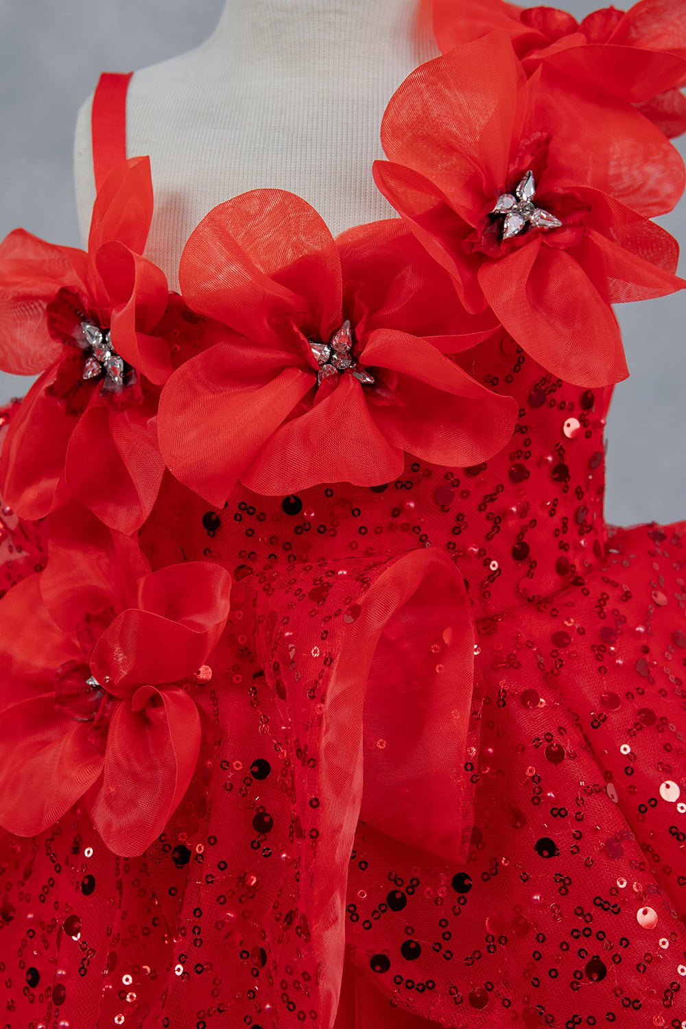 Close-up front view of red dress showing crystal floral detail and sequin texture