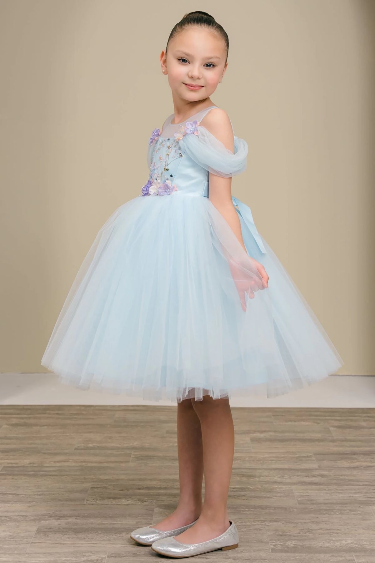 A light blue flower girl dress with floral embellishments.