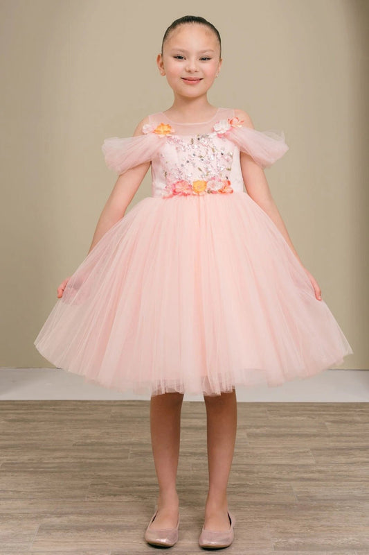 Shown in a front view, the Pink flower girl dress has sheer puff sleeves and floral waist trim above a full tulle skirt.