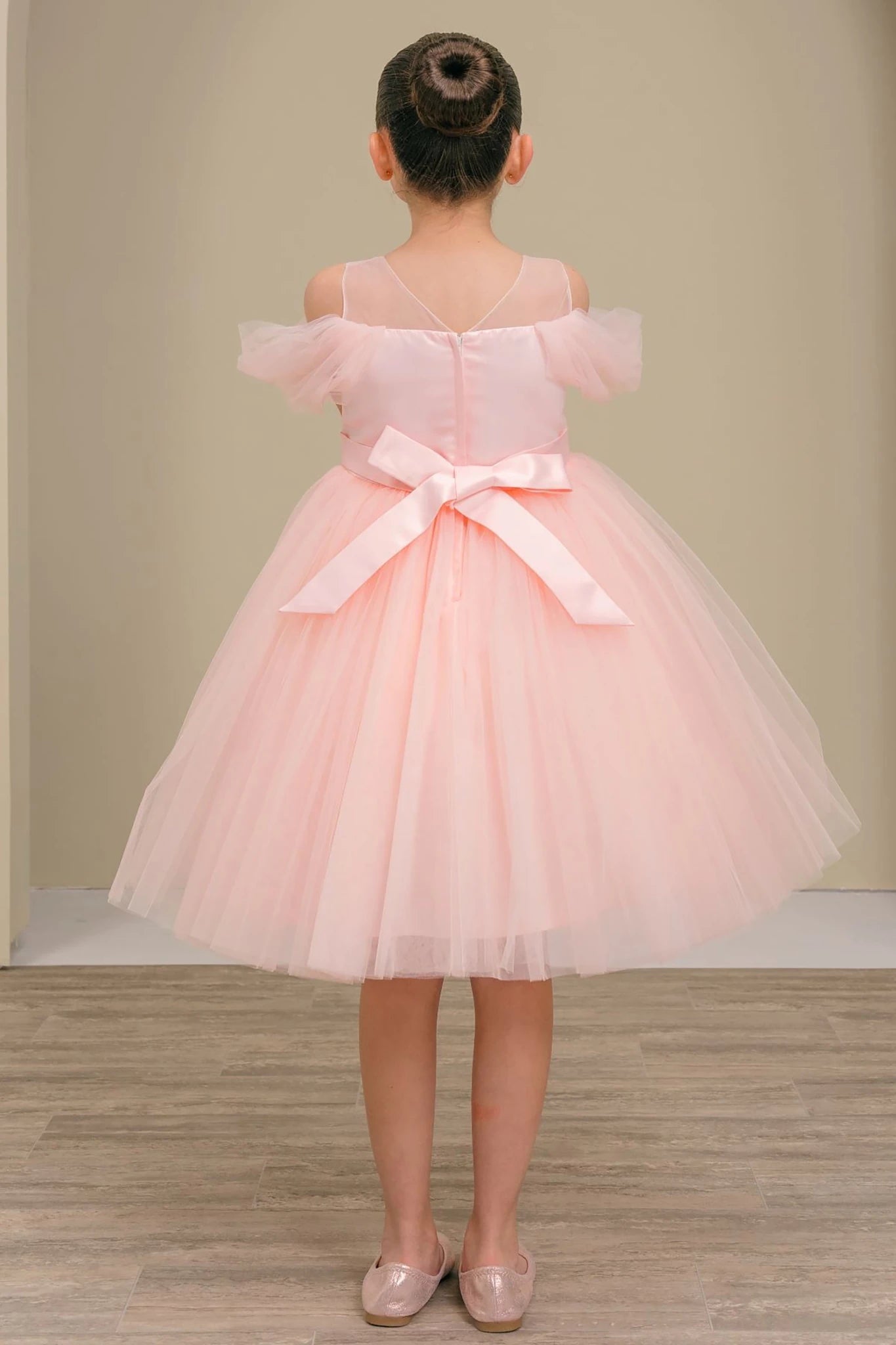 A pink flower girl dress with a bow.