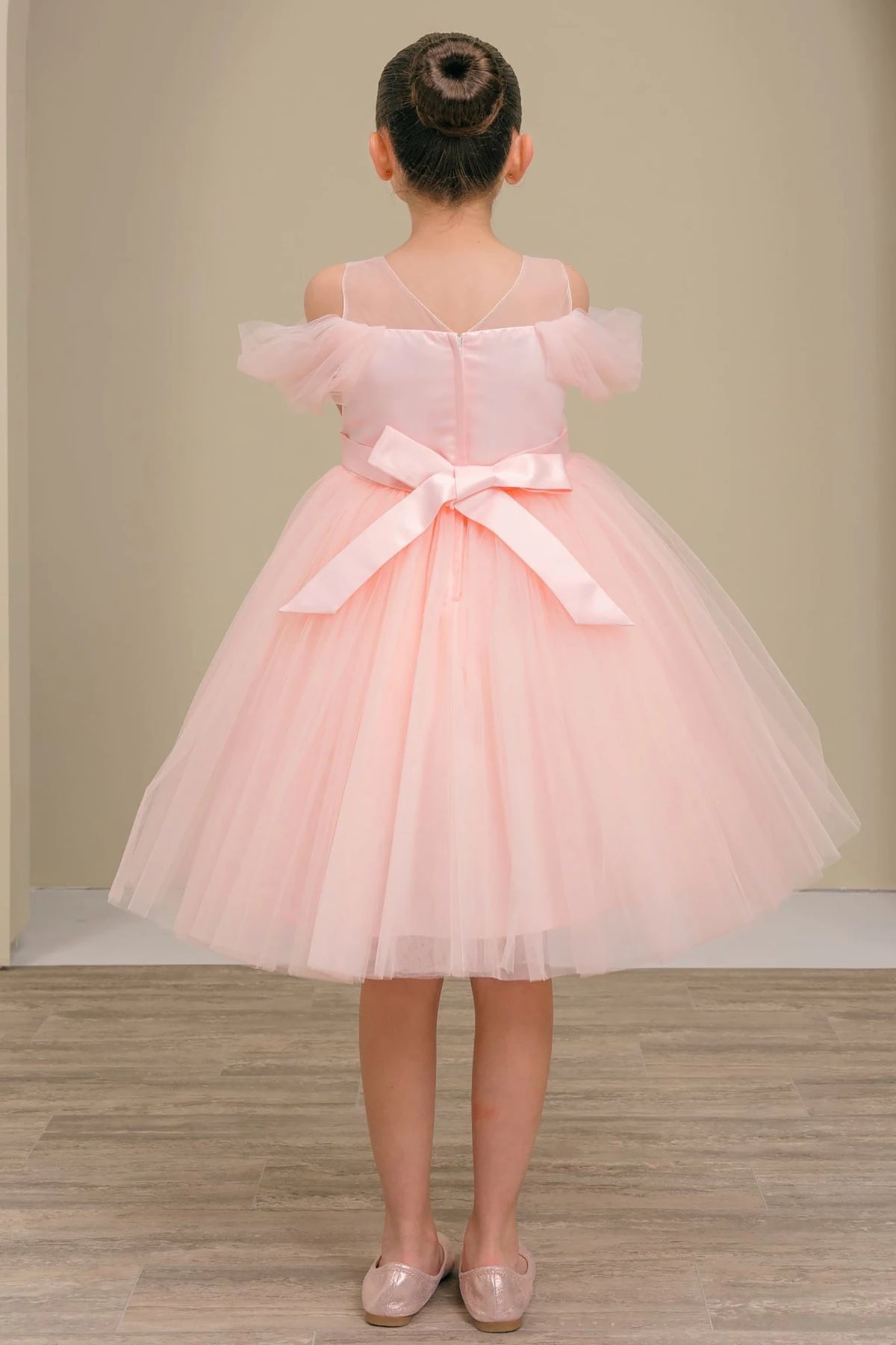 A pink flower girl dress with a bow.