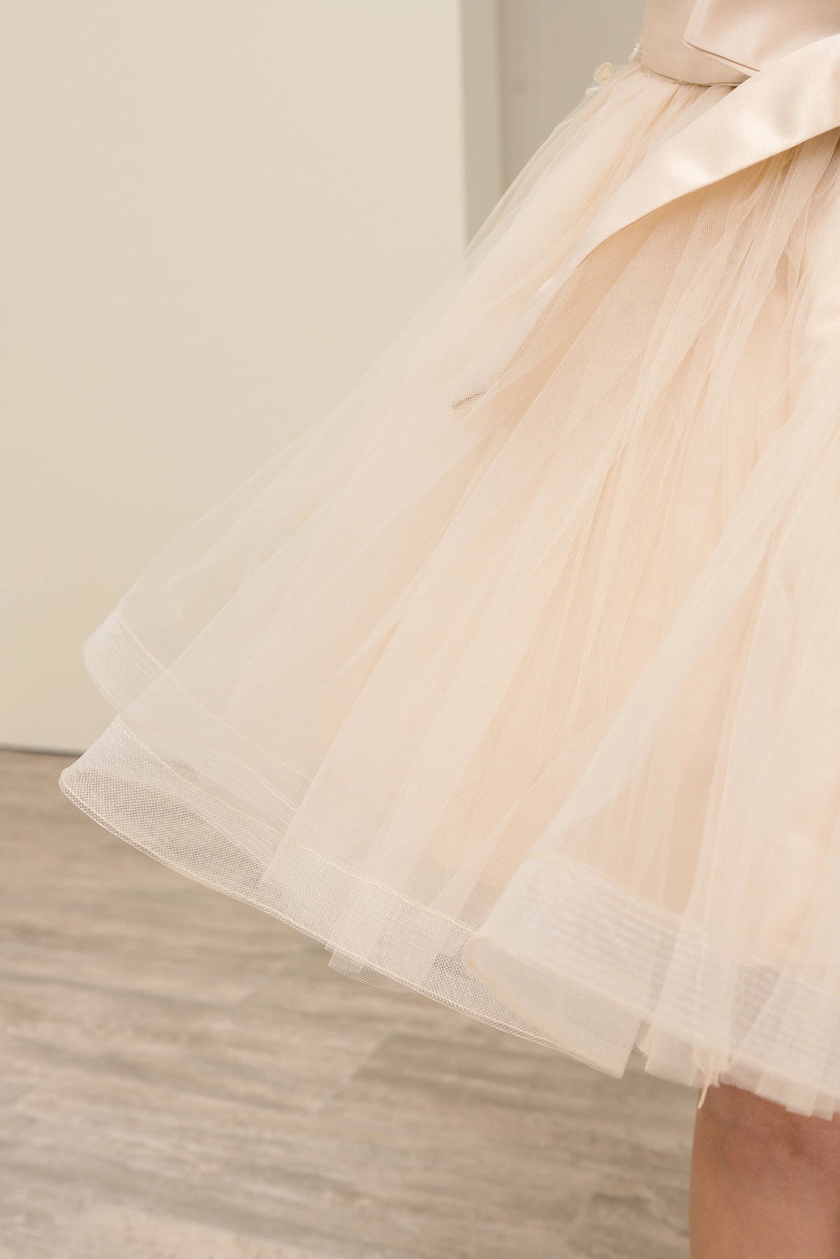 View of this Champagne flower girl dress with layered tulle skirt beneath the satin bow.