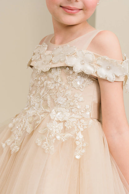 Details of the Champagne flower girl dress include dimensional flowers around the off-shoulder trim.