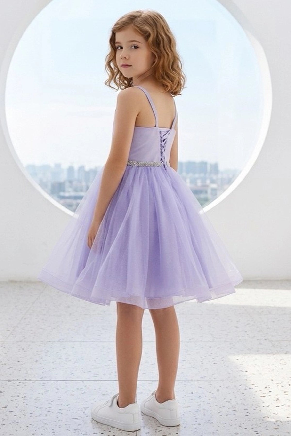 A Lilac flower girl dress showing lace-up back beneath crossed straps.
