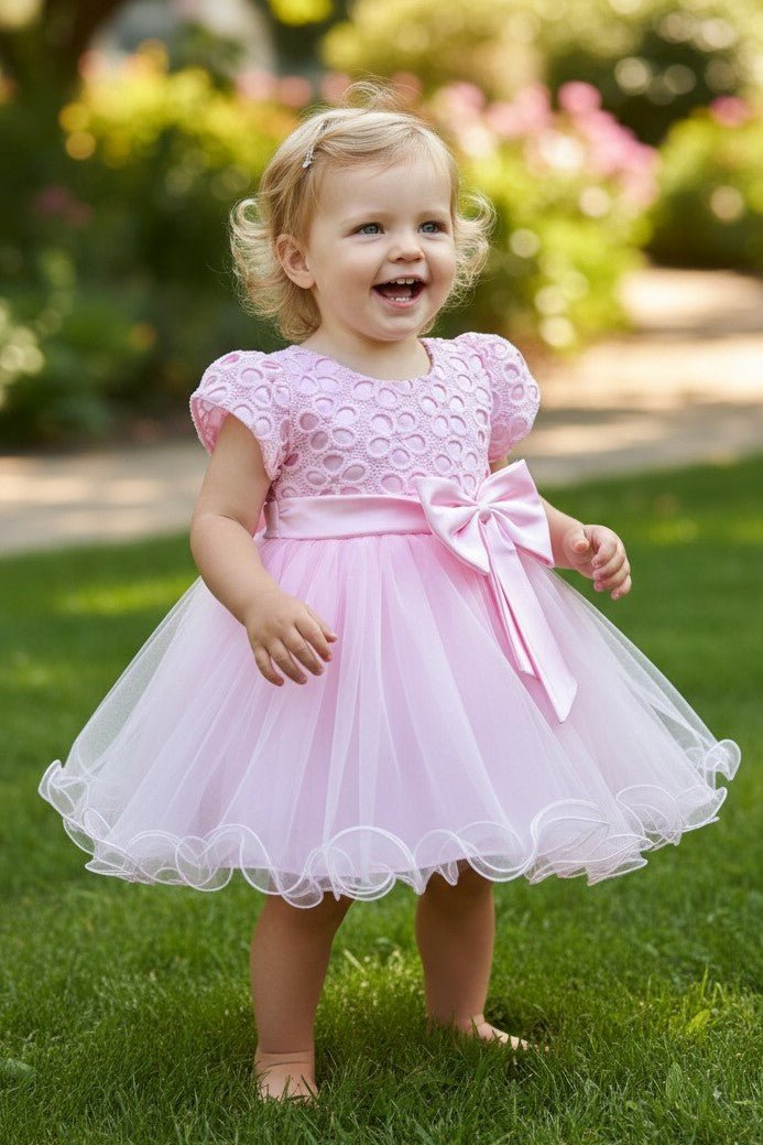 Pink flower girl Dress Front View With Layered Skirt And Oversized Bow Detail.